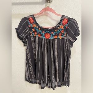 a very cute blouse with flowered detailing at the top